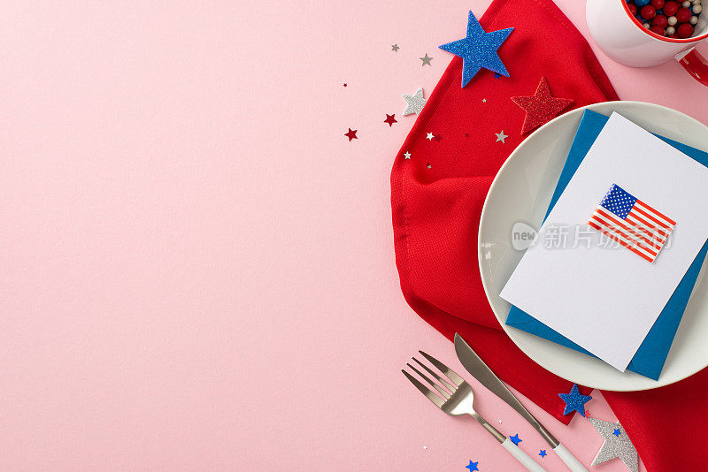爱国餐桌布置:盘子、餐具、马克杯、餐巾纸、国旗明信片、信封、星星、彩纸的俯视图，排列在浅粉色的背景上。为文字或广告留白的空间