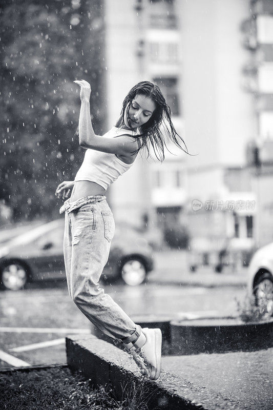 在夏雨中跳舞的女性的黑白视图