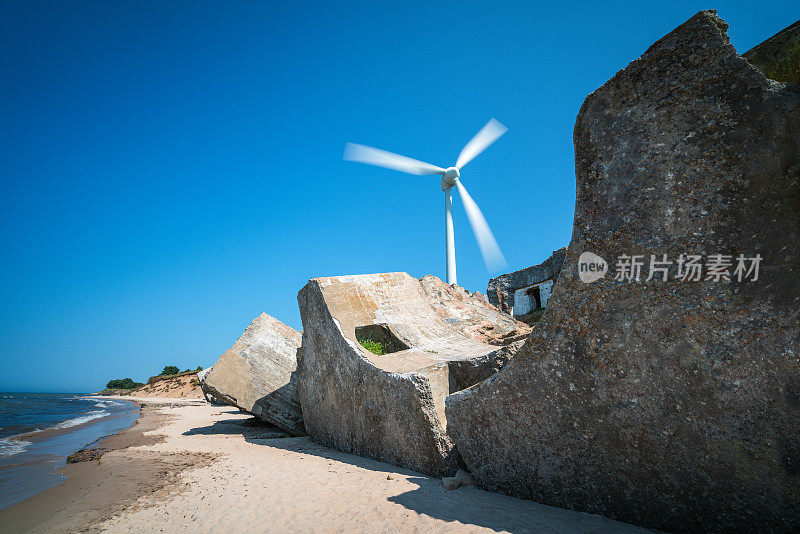 拉脱维亚利耶帕亚附近波罗的海沿岸废弃的旧防御工事。背景中的大型风力涡轮机