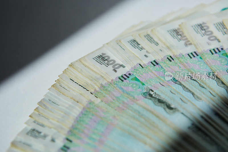 1000卢布面值的俄罗斯纸币躺在白色的表面上，一大堆钱。经济和银行体系的概念。