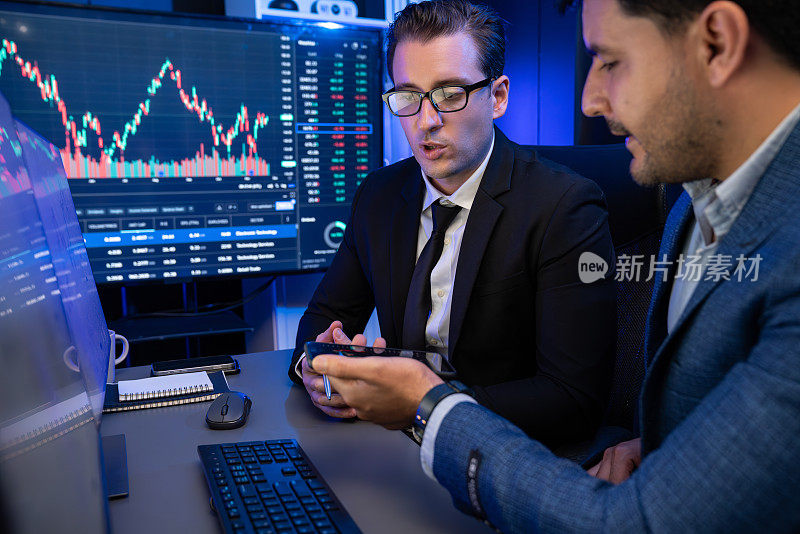 两个证券交易所的交易员讨论动态投资图。适于销售的。