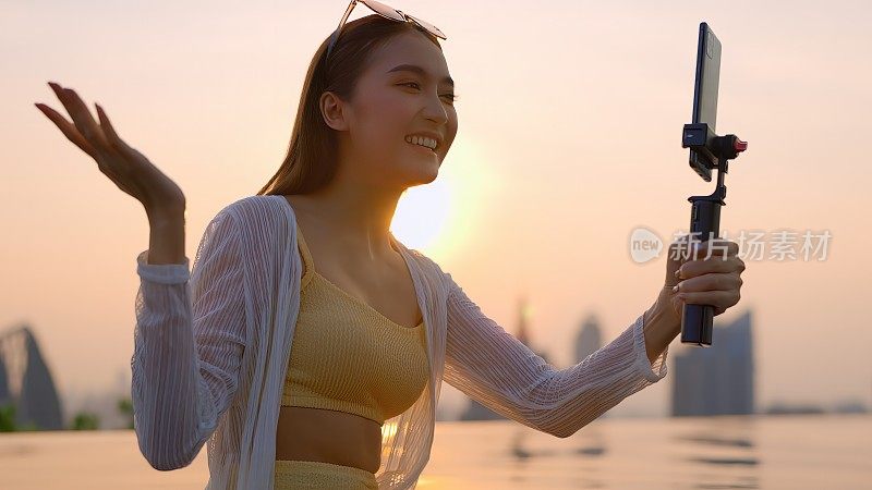 夏季休闲休闲亚洲女性黄色比基尼享受视频通话与她的朋友通过智能手机亚洲网红广播生活方式分享经验与她的追随者在社会