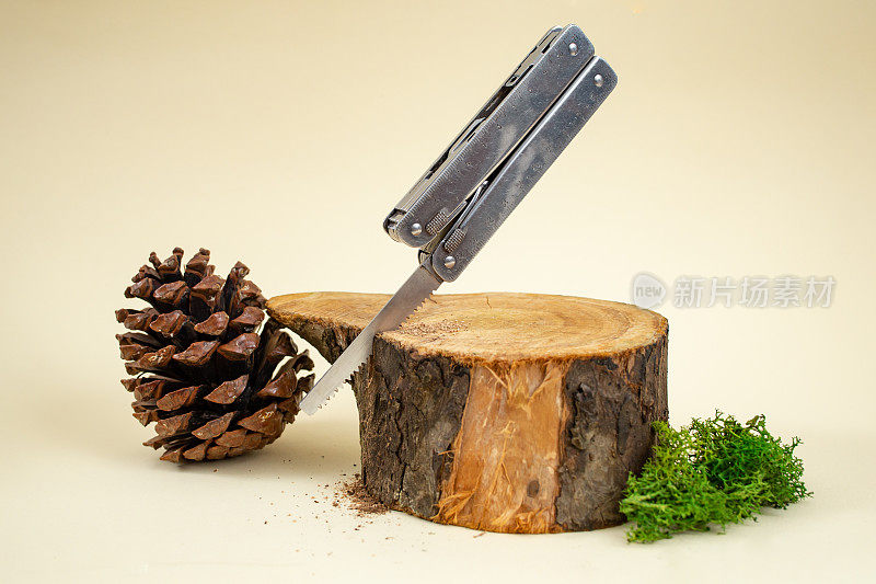瑞士军刀锯原木在米色背景，软焦点近