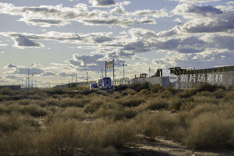 半卡车和拖车穿越美国和墨西哥边境在圣特蕾莎新墨西哥州和华雷斯奇瓦瓦在黄昏下美丽的部分多云的云景