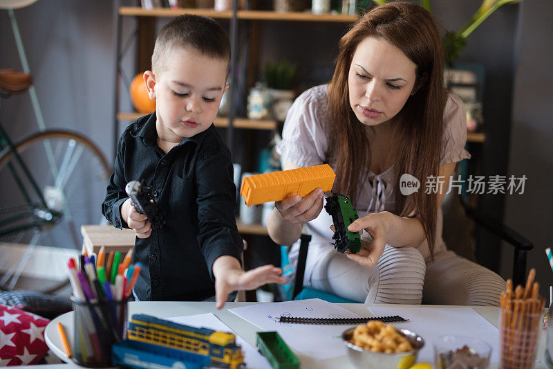 孩子在妈妈面前玩玩具火车