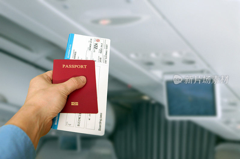 商务旅客在飞机内，持有护照、机票、登机牌