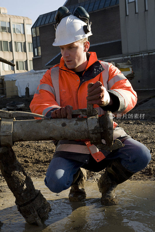 一个年轻的建筑工人在建筑坑里