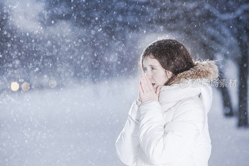 雪下穿着白色夹克的漂亮少女