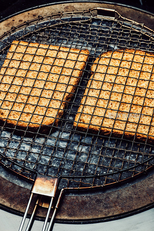 老式的烤面包放在烤炉上的烤架上