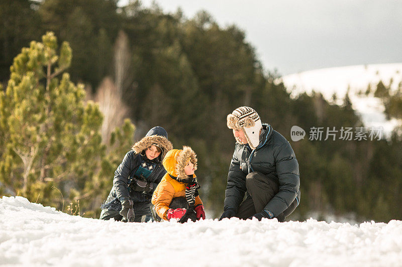 父亲和儿子们在雪中玩耍