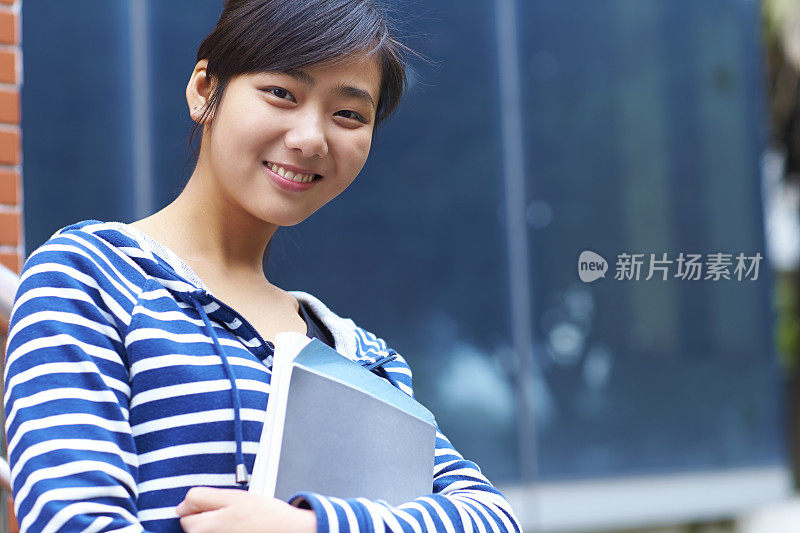可爱的亚洲大学生在镜头前微笑的肖像