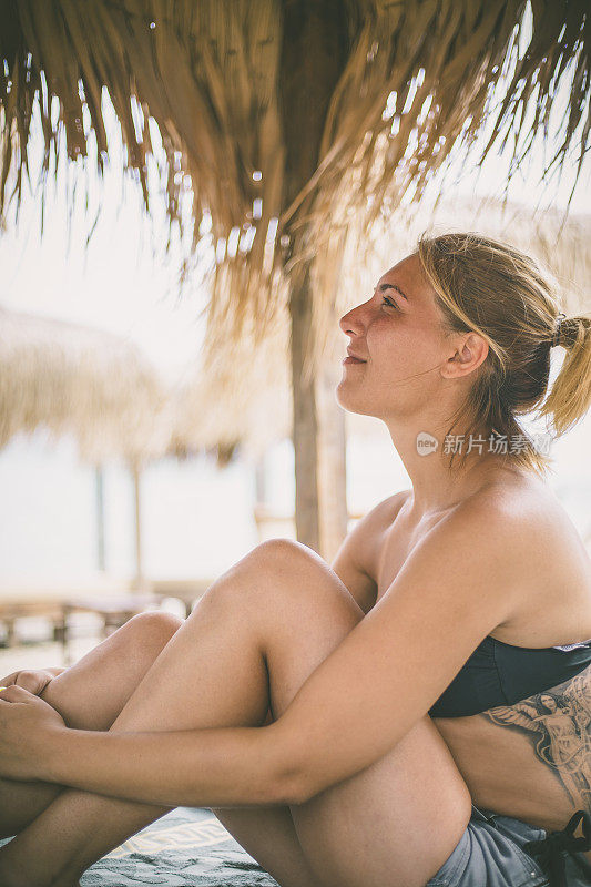 年轻的女子在夏天望着天空和大海