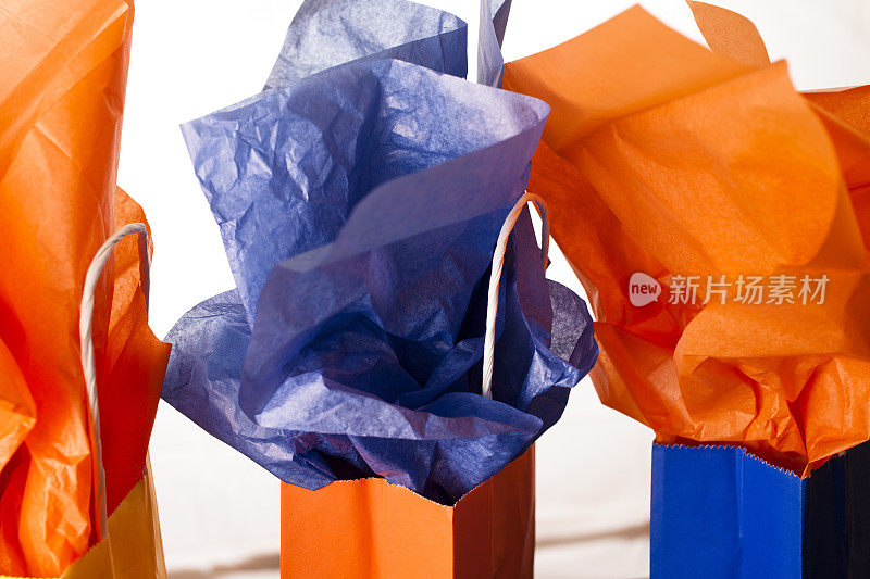 礼品袋在橙色，蓝色在白色的背景。