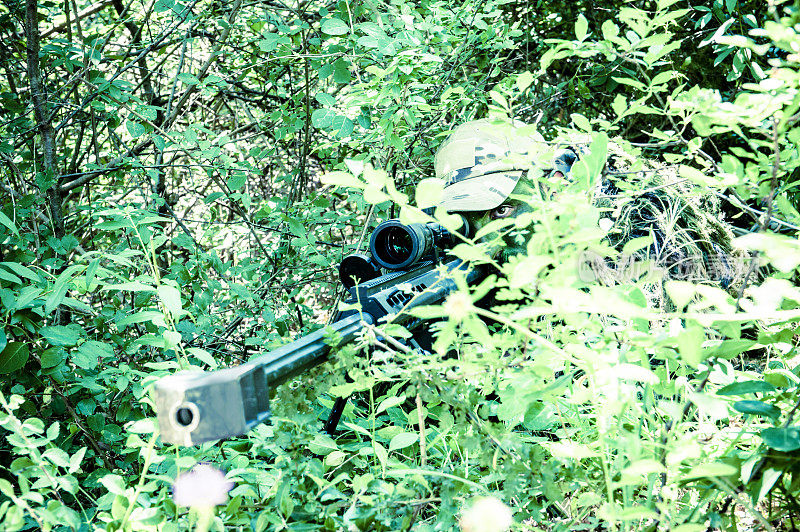 狙击手在树林中隐藏和瞄准巴雷特M82A1步枪