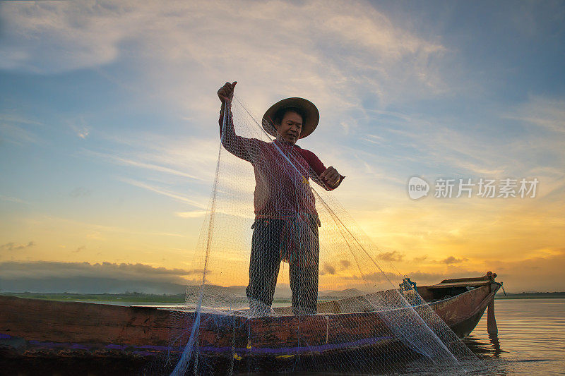 清晨，泰国渔夫在湖边钓鱼。