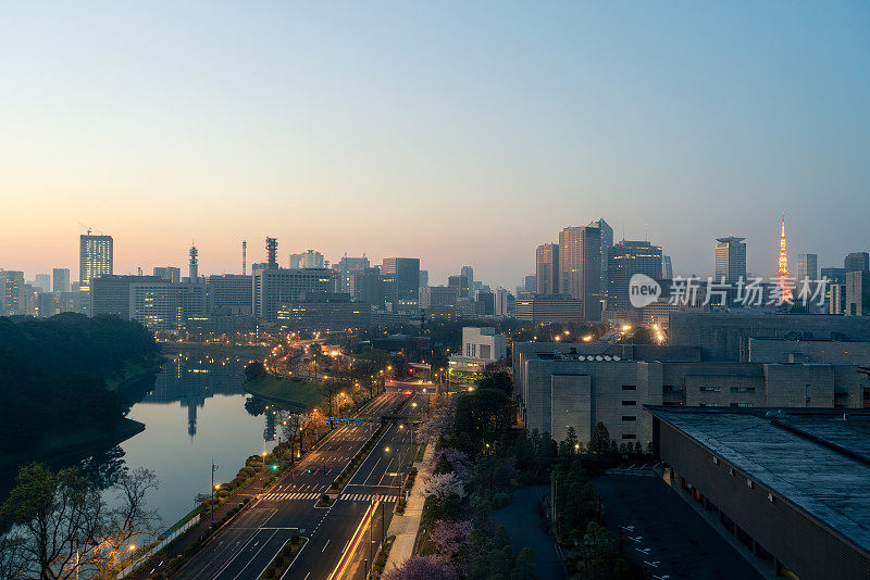 在日本东京的丸之内区，市中心城市的天际线和摩天大楼以东京塔为背景。