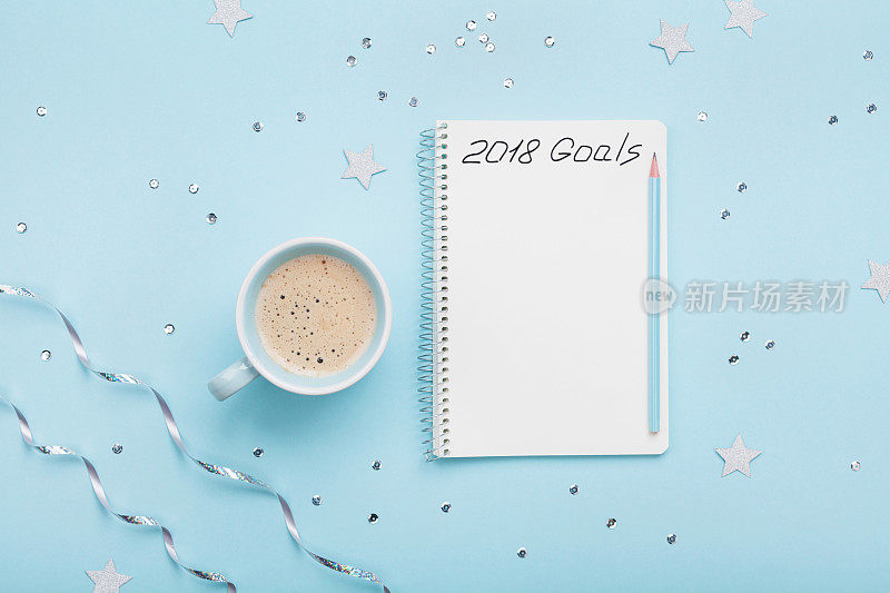一杯咖啡，一本写着2018年目标的笔记本。计划的概念。前视图。