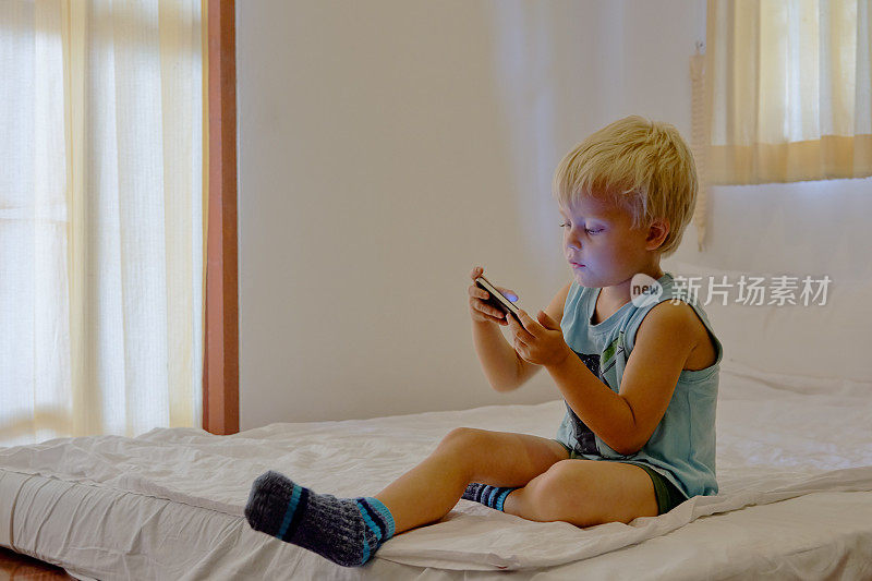 男孩在便携式设备上玩电子游戏