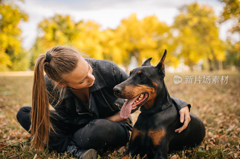 一个女人在玩她的杜宾犬