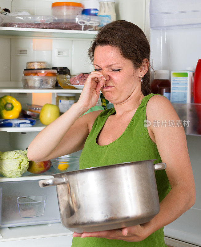 拿着不干净的食物靠近冰箱的女人
