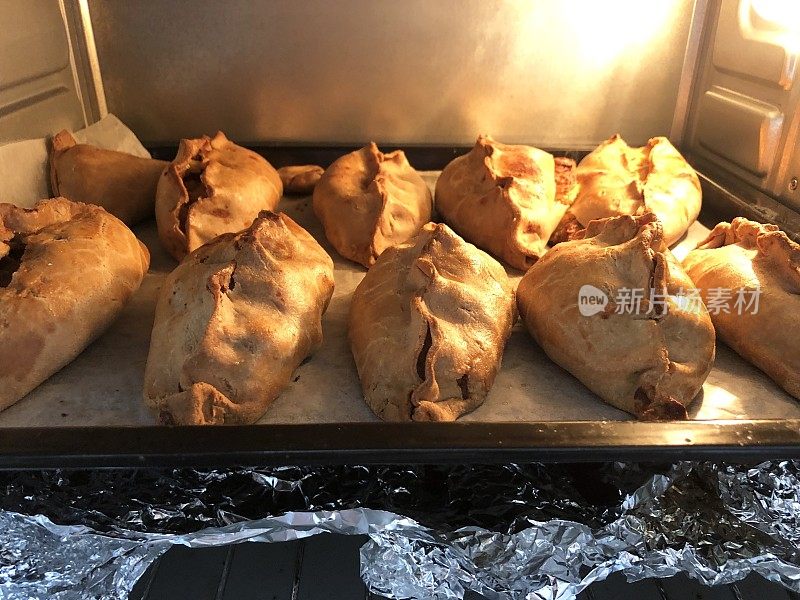 想象自制康沃尔馅饼在烤箱中烘烤，馅饼在非高汤托盘中烹饪