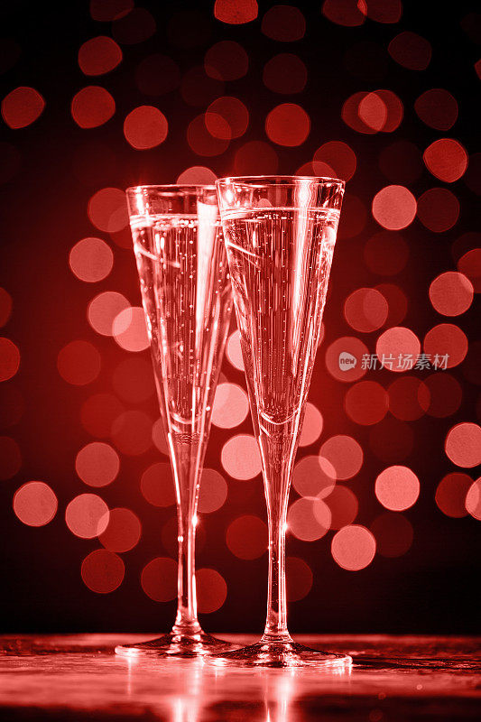 两杯香槟，背景是深焦。紫外光色调，2018年度流行色。活珊瑚主题——2019年度色彩