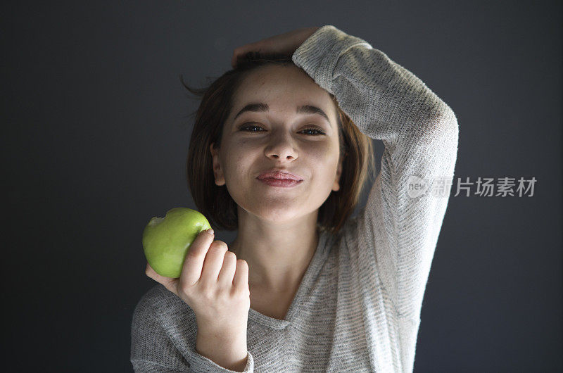 可爱的年轻女子吃青苹果