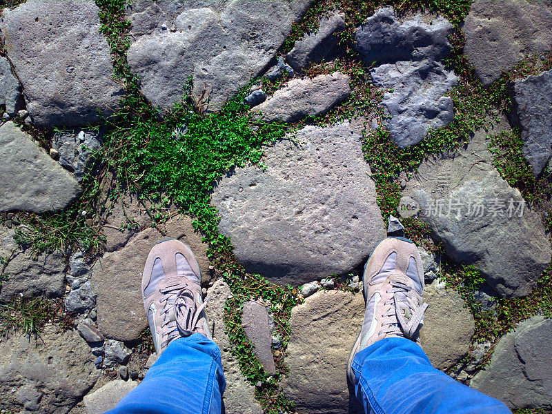 脚的石头。双脚踩在鹅卵石上。那个人站在石头上。