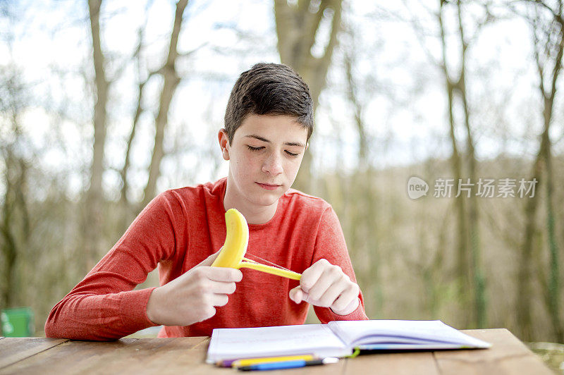 一个在城市公园里学习的少年。吃健康零食的时间到了