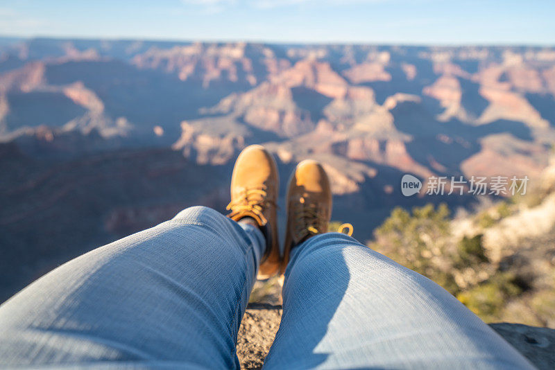 女性在大峡谷顶端放松的个人视角脚视图;人们旅游度假放松的概念