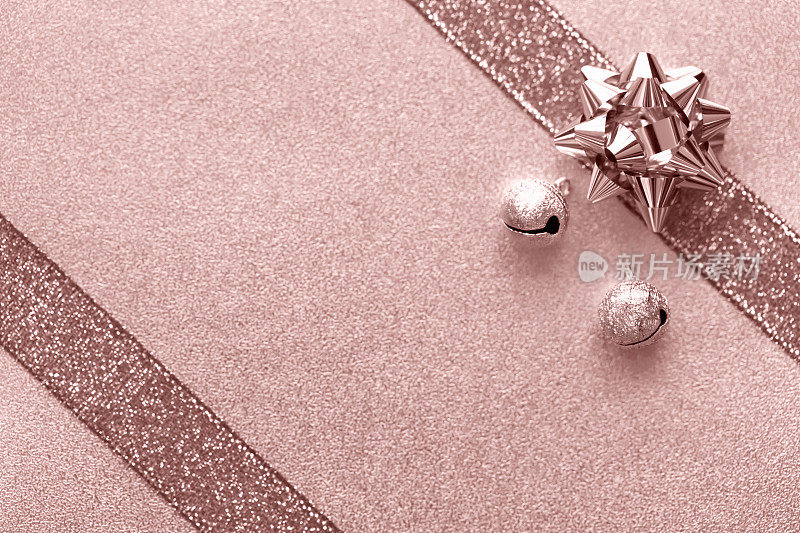 圣诞礼物玫瑰金闪光缎带系蝴蝶结包装箔纸散焦背景发光粉千禧淡粉色复古设计模板Fete珠光宝气的概念假日模式闪亮的背景平Lay复制空间