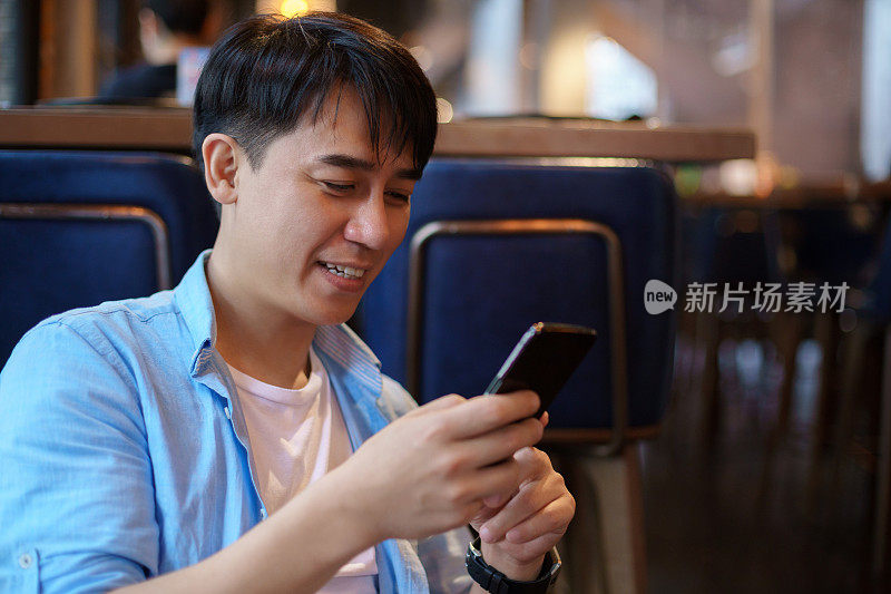 年轻的亚洲男子使用智能手机