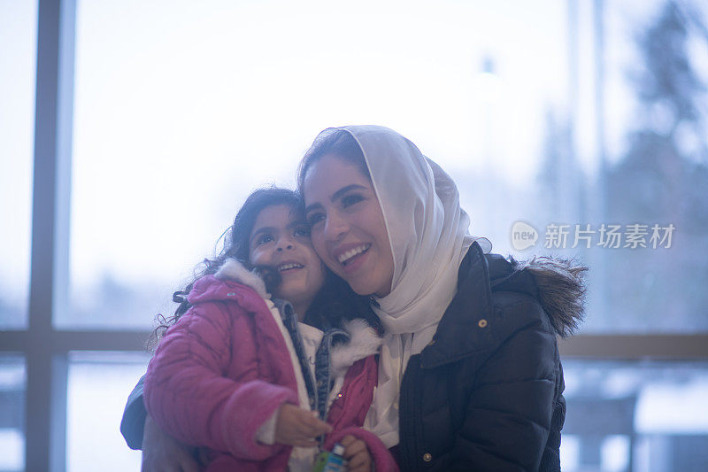 穆斯林母亲和女儿在机场库存照片