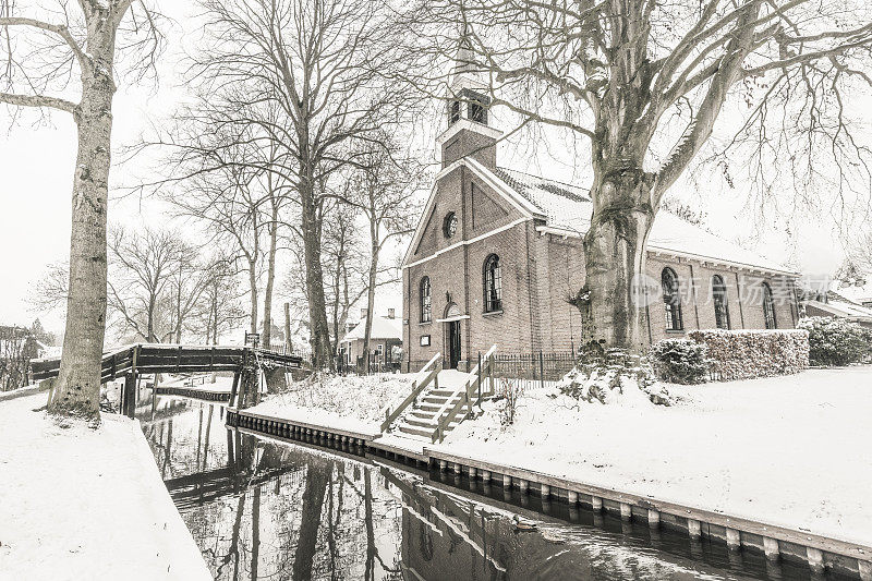 在一个寒冷但美丽而平静的冬天，Giethoorn村的运河和积雪