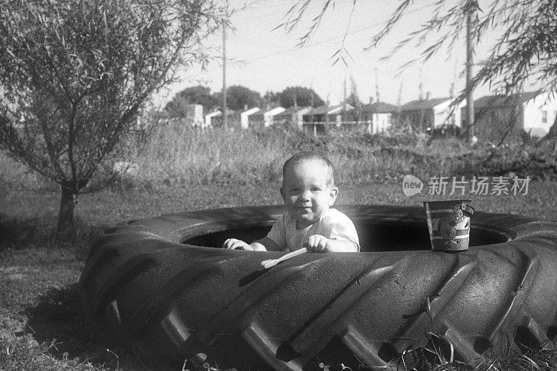 1952年，婴儿在拖拉机轮胎沙盒里玩