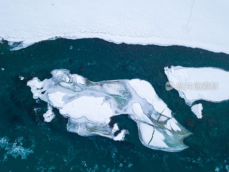 航拍的蓝色和绿色的河流与雪和碎冰在冬季冰漂移在俄罗斯阿尔泰山脉。