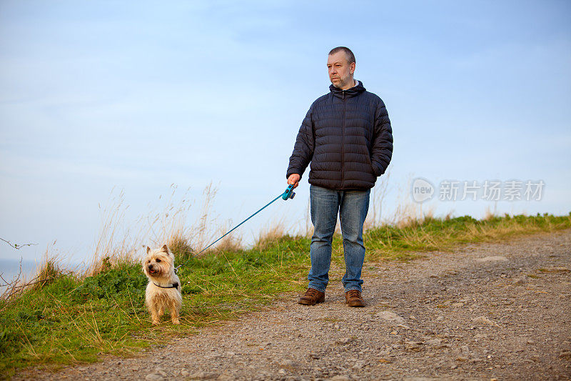 一个成熟的男人在山里遛狗