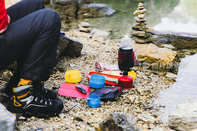 一名男子在瑞士山区徒步旅行时准备晚餐