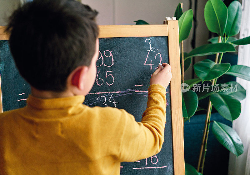 在家教育。6-7岁的孩子在家学习数学。