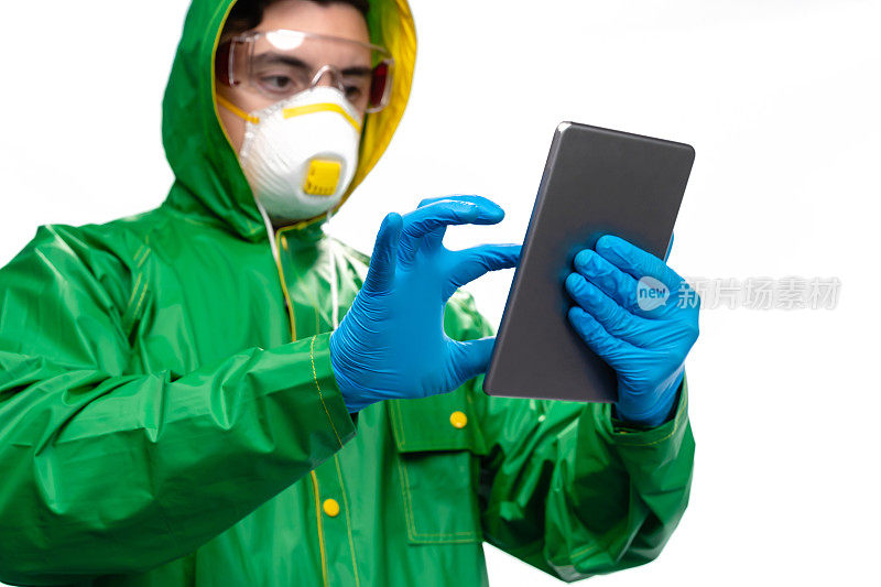年轻工程师或工人戴着防护口罩和手术手套，在白色背景上使用数码板