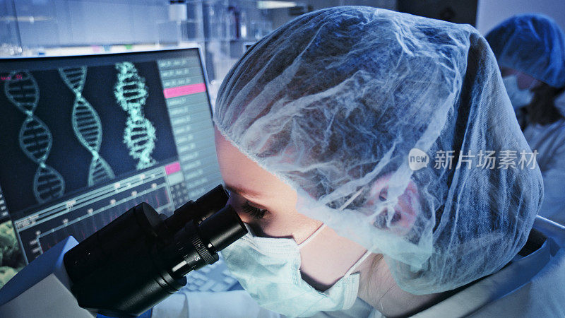 研究DNA突变的女医生。前景中有DNA螺旋结构的计算机屏幕