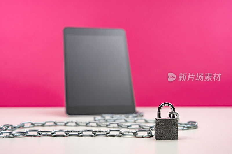 数字平板电脑锁定与挂锁和链在粉红色的背景