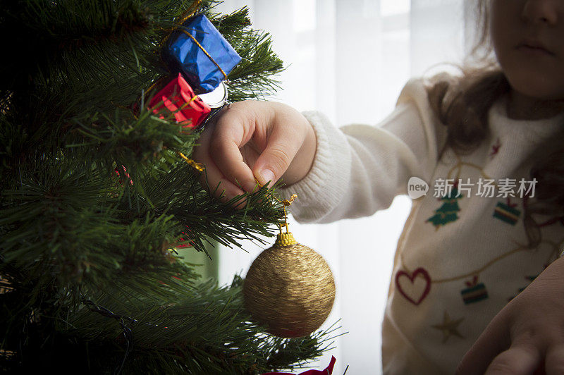 小女孩在家里装饰圣诞树