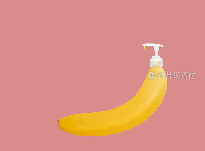 黄色成熟香蕉与分配器，化妆品。皮肤护理的概念。复制空间，粉色背景。