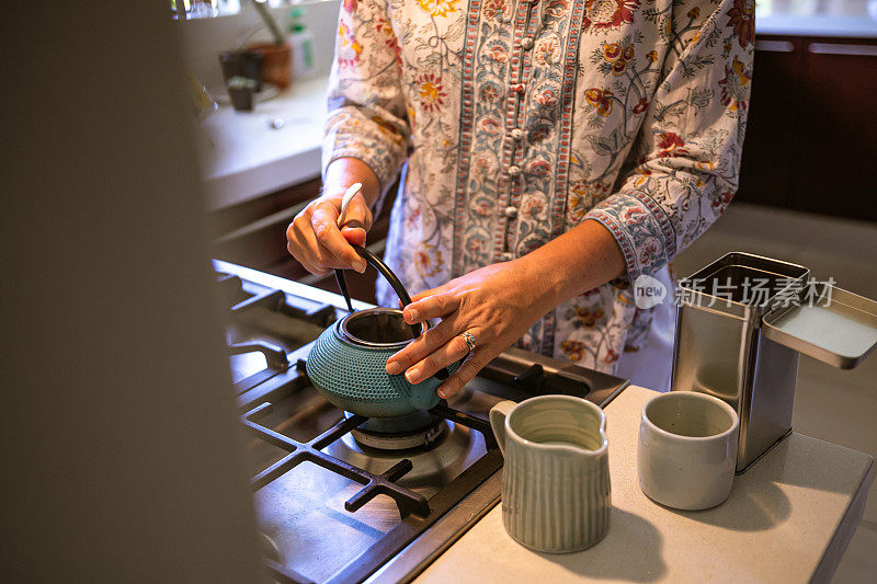 一名妇女正在准备一壶自家冲泡的散叶红茶