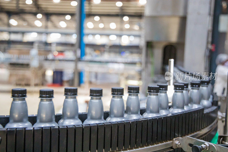 工业，商业，工厂，装瓶厂-瓶子装满了新鲜的饮料移动在传送带到工厂的包装部分