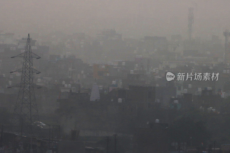 印度北方邦新德里的城市景观图片，印度公寓楼的屋顶被污染的雾霾天空包围，雾霾天空是由汽车尾气和工厂排放造成的