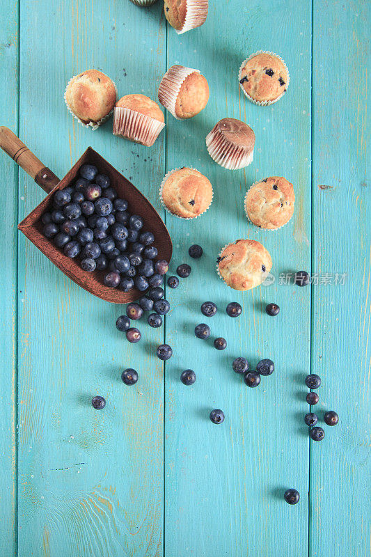 小蓝莓松饼与新鲜蓝莓在蓝绿色木材