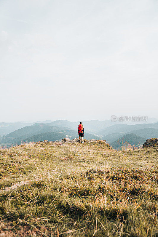 徒步旅行者在长满草的山脊上放松的观点