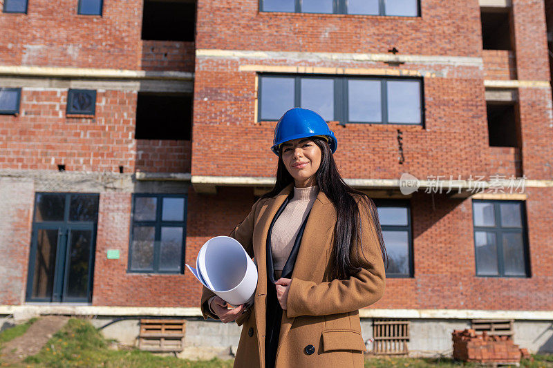 白人女建筑师自豪地站在建筑施工前